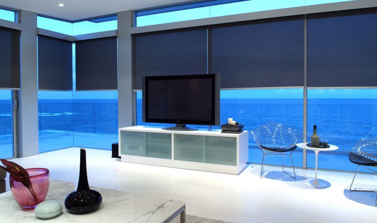 Comfy furnishings in a living room with rolling blinds.